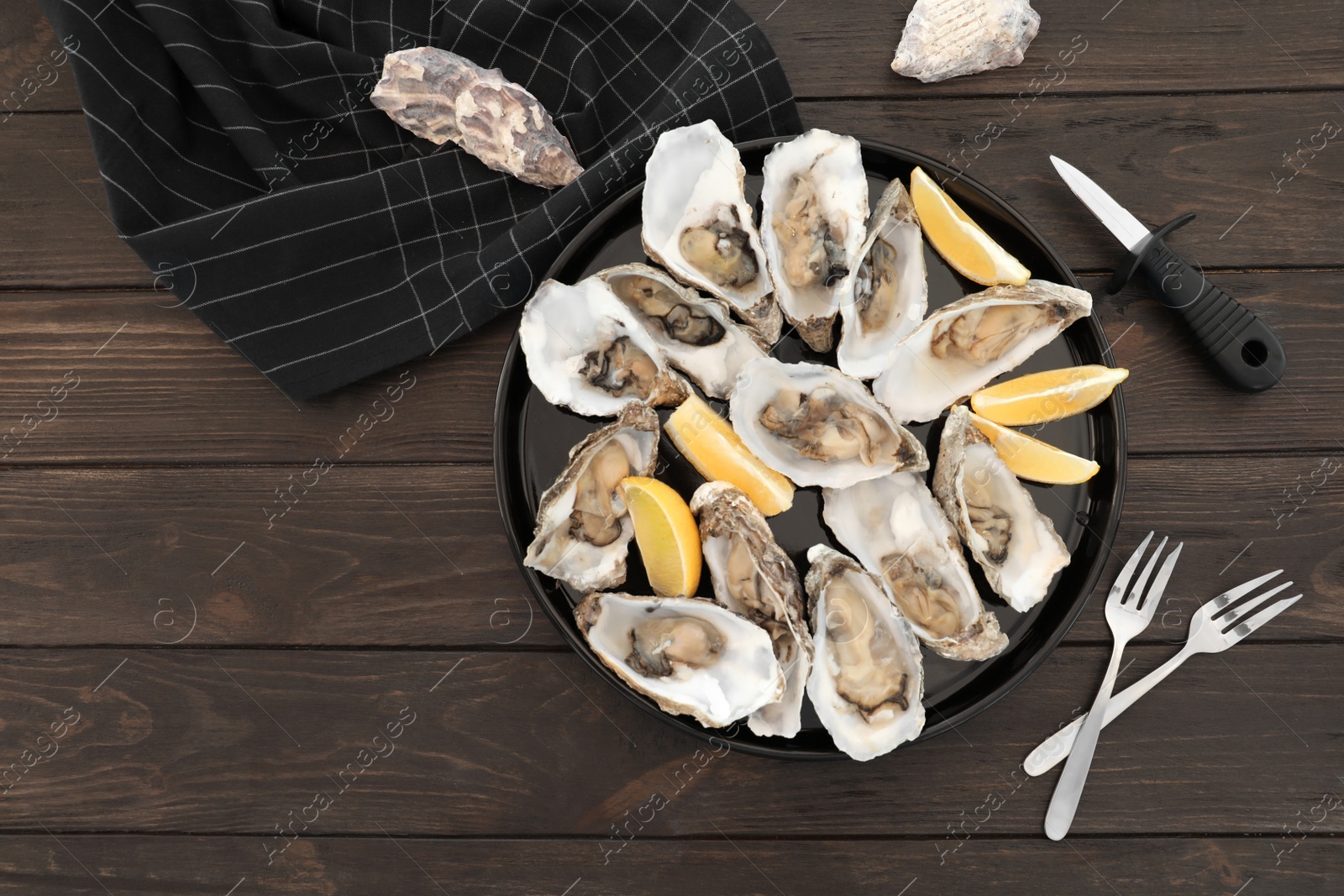 Photo of Fresh oysters with cut juicy lemon and space for text on table, flat lay