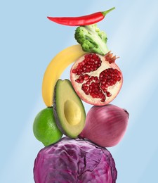 Stack of different vegetables and fruits on pale light blue background
