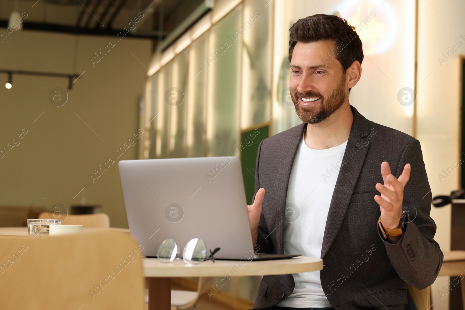 Photo of Man having video chat via laptop in cafe