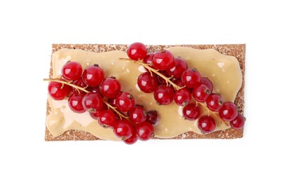 Fresh crunchy rye crispbread with peanut butter and red currant isolated on white, top view