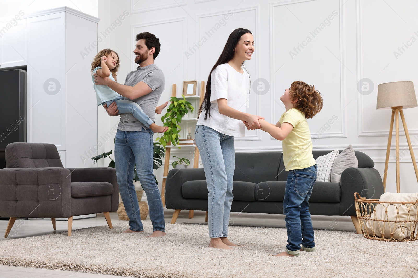 Photo of Happy family dancing and having fun in living room