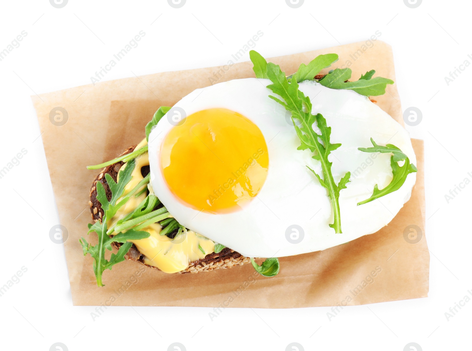 Photo of Delicious sandwich with arugula and fried egg isolated on white, top view