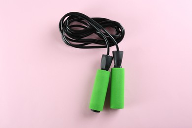 Skipping  rope on pink background, top view. Sports equipment
