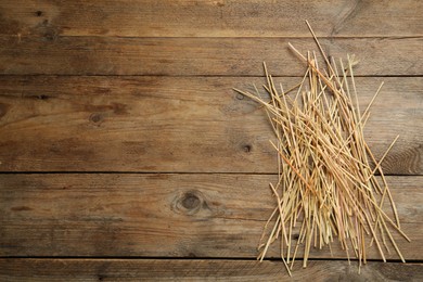 Dried hay on wooden background, top view. Space for text