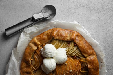 Photo of Delicious apple galette served with ice cream on light grey textured table, top view