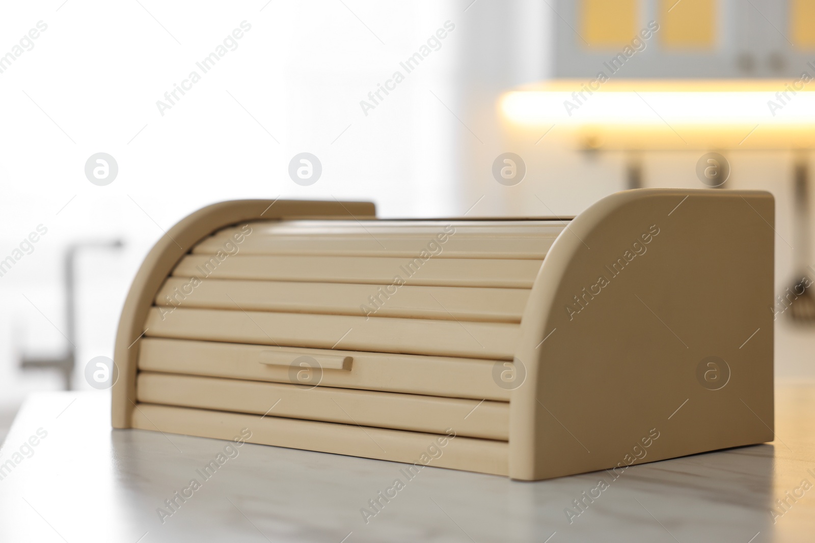 Photo of Wooden bread box on white table in kitchen, closeup