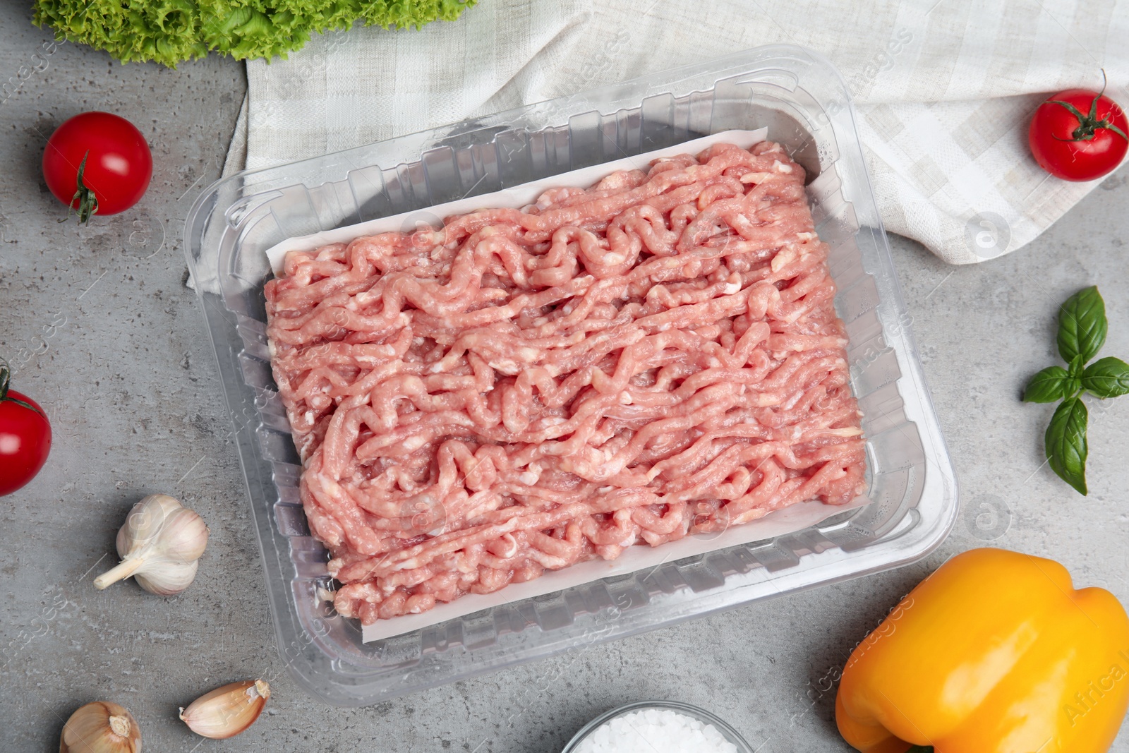 Photo of Raw chicken minced meat and ingredients on grey table, flat lay
