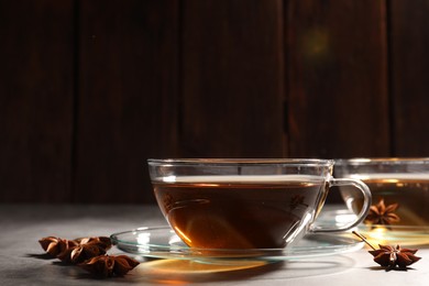 Aromatic tea with anise stars on light grey table. Space for text