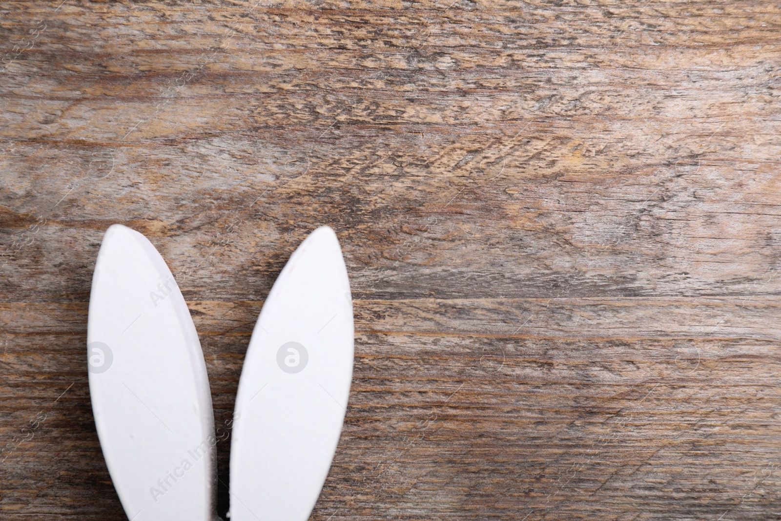 Photo of Decorative bunny ears and space for text on wooden background, flat lay. Easter holiday