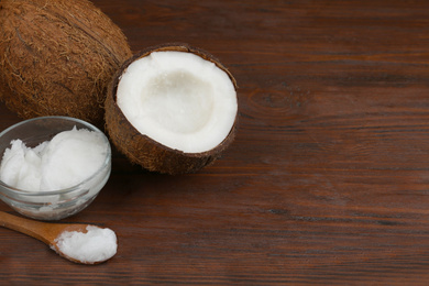 Composition with organic coconut oil on wooden table, space for text. Healthy cooking