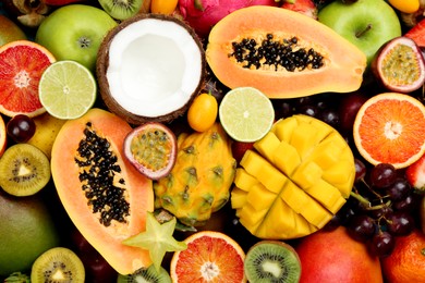 Photo of Many different delicious exotic fruits as background, top view