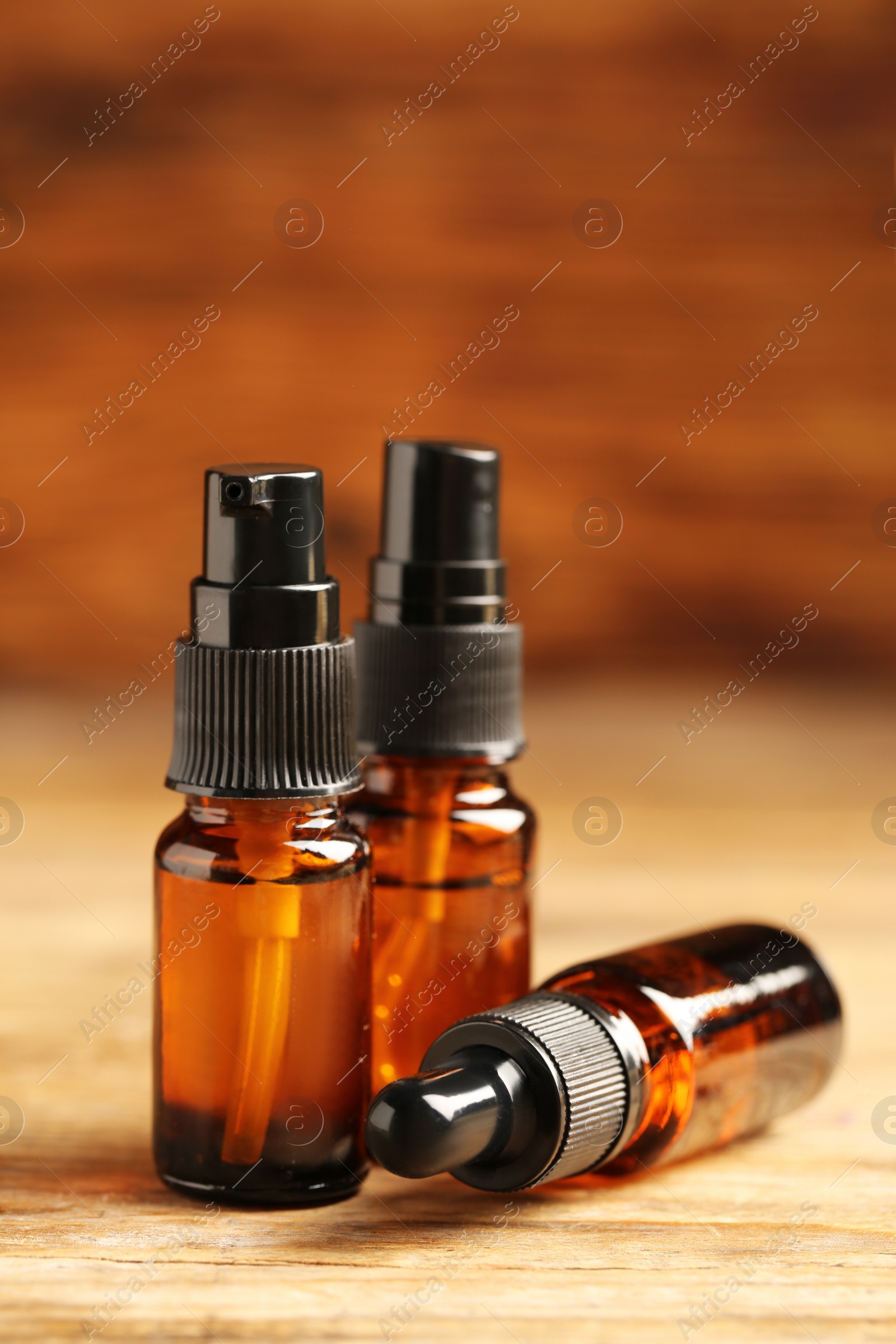 Photo of Bottles with oil on wooden table. Natural cosmetics