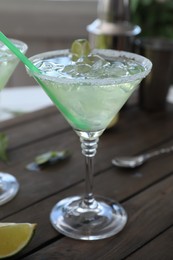 Delicious Margarita cocktail in glass on wooden table, closeup