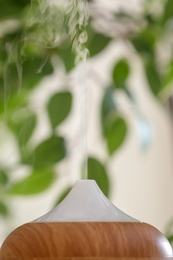 Aroma oil diffuser lamp on blurred background, closeup