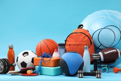 Photo of Many different sports equipment on light blue background