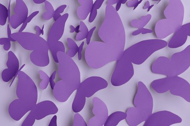 Bright violet paper butterflies on white wall