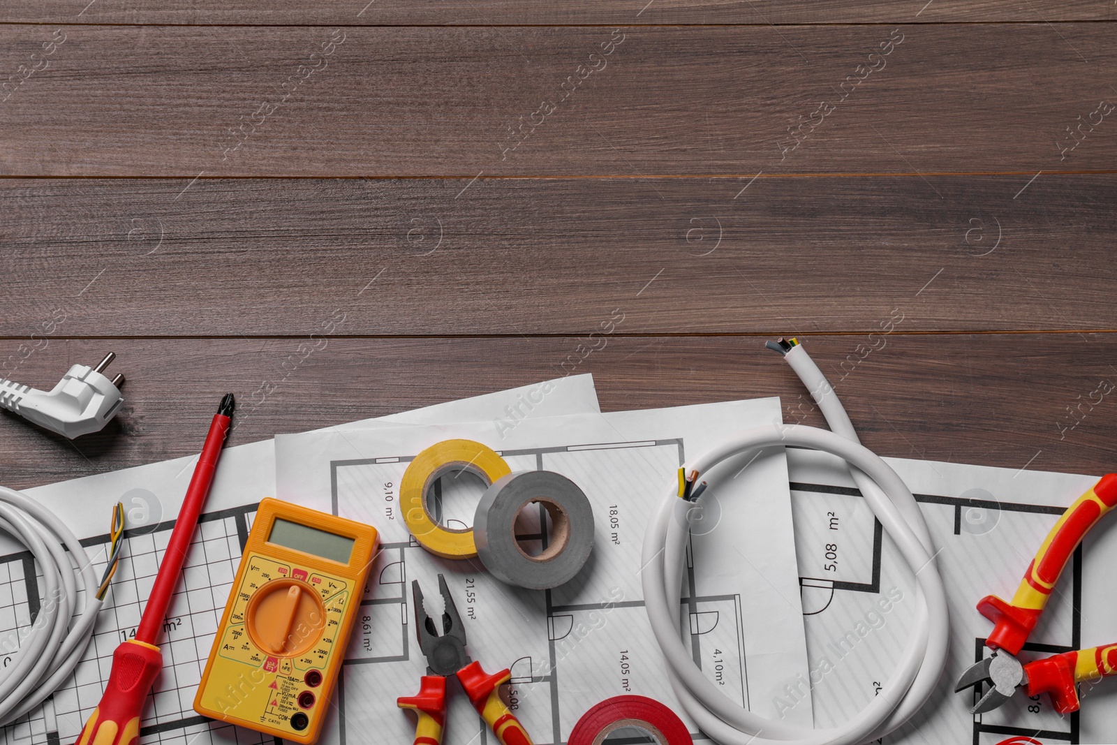 Photo of Different wires and electrician's tools on wooden table, flat lay. Space for text