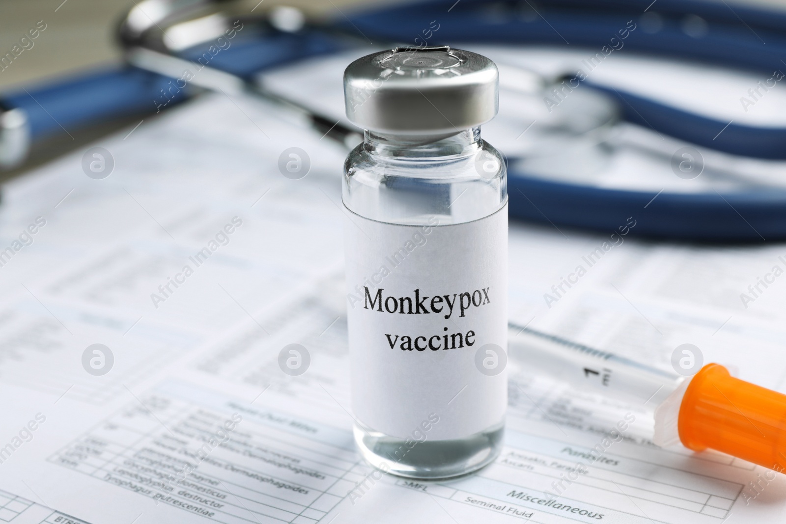 Photo of Monkeypox vaccine in vial and syringe on medical forms, space for text