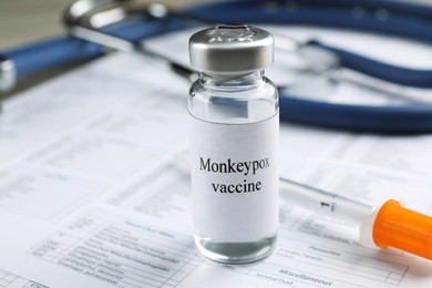 Photo of Monkeypox vaccine in vial and syringe on medical forms, space for text