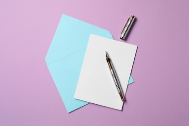 Blank sheet of paper, letter envelope and pen on violet background, top view