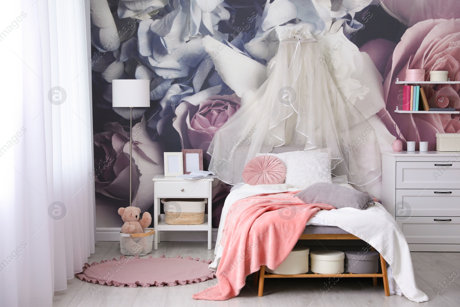 Photo of Teenage girl's room interior with comfortable bed and floral wallpaper. Idea for stylish design