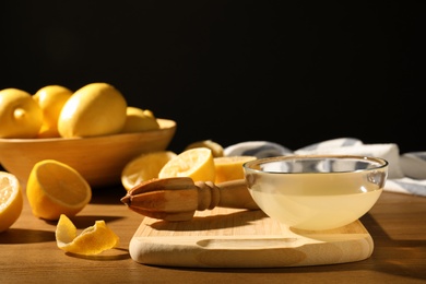 Photo of Composition with lemon juice and wooden reamer on table