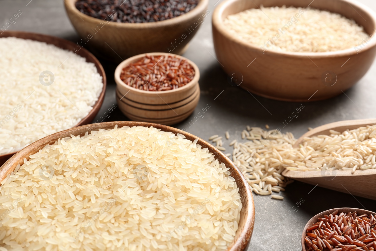 Photo of Brown and other types of rice on grey table