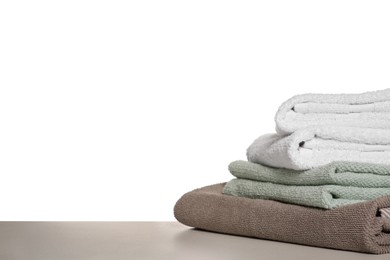 Photo of Soft colorful terry towels on light table against white background, space for text