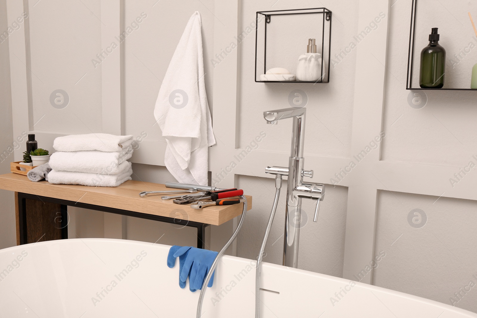 Photo of Professional plumbing tools and installed water tap in bathroom