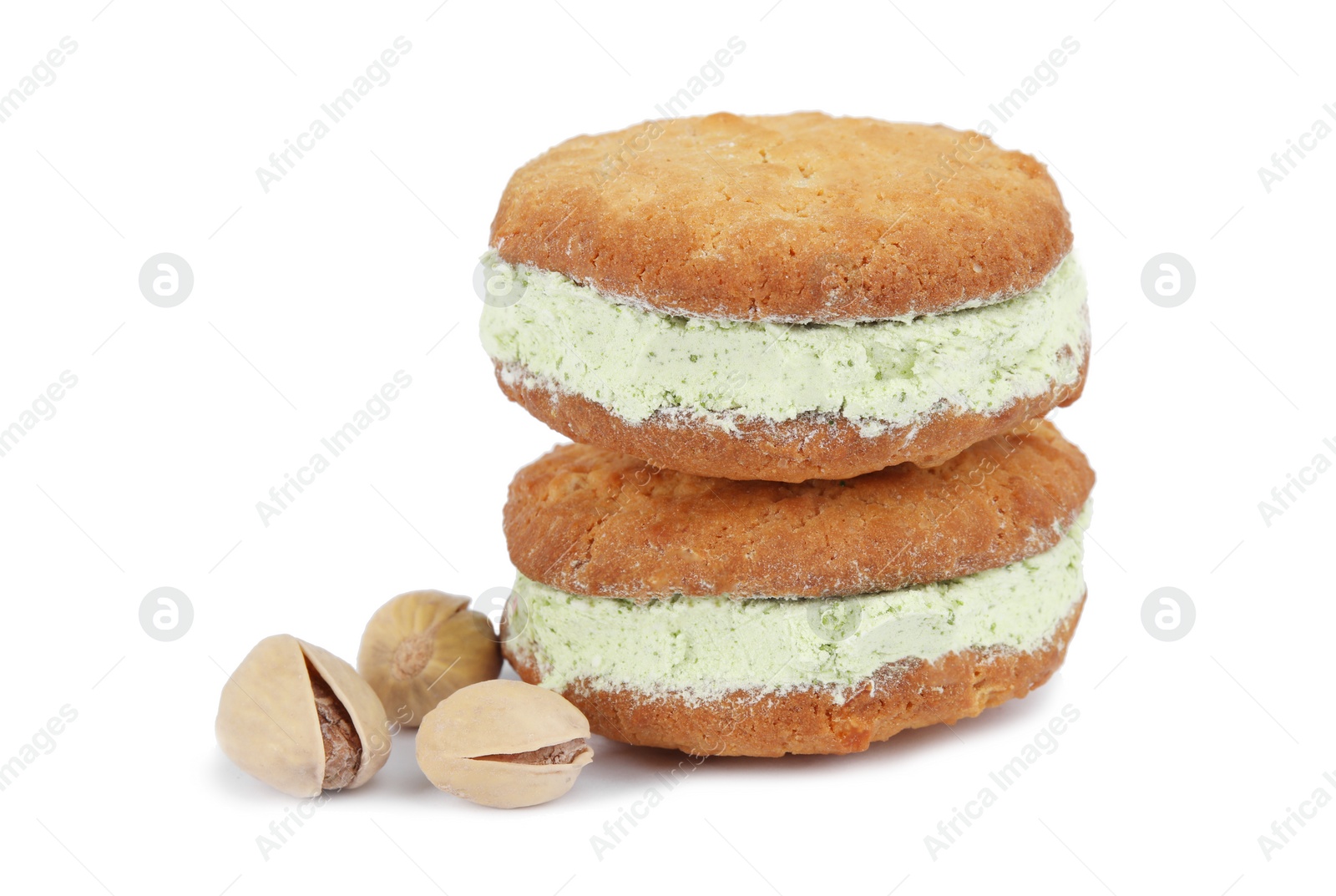 Photo of Sweet delicious ice cream cookie sandwiches and pistachios on white background