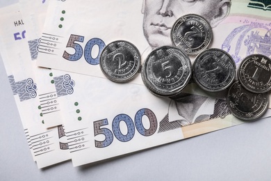 Photo of Ukrainian money on light grey background, flat lay