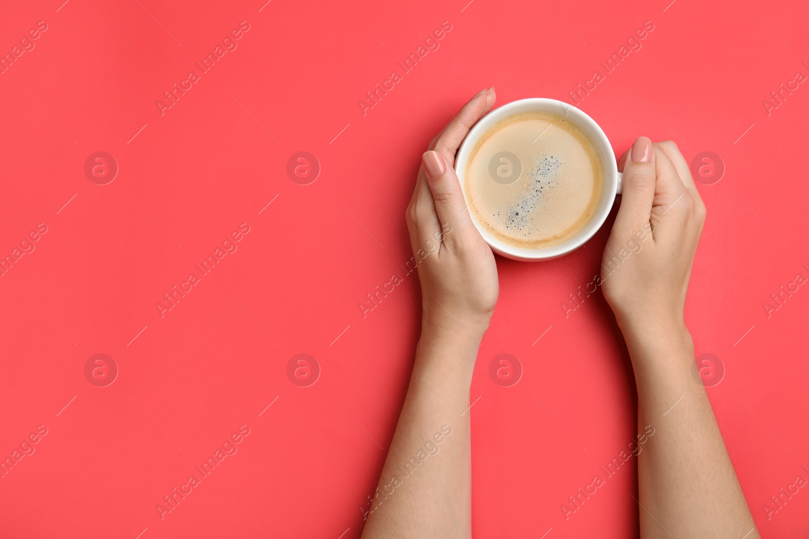 Photo of Woman with cup of coffee on red background, top view. Space for text