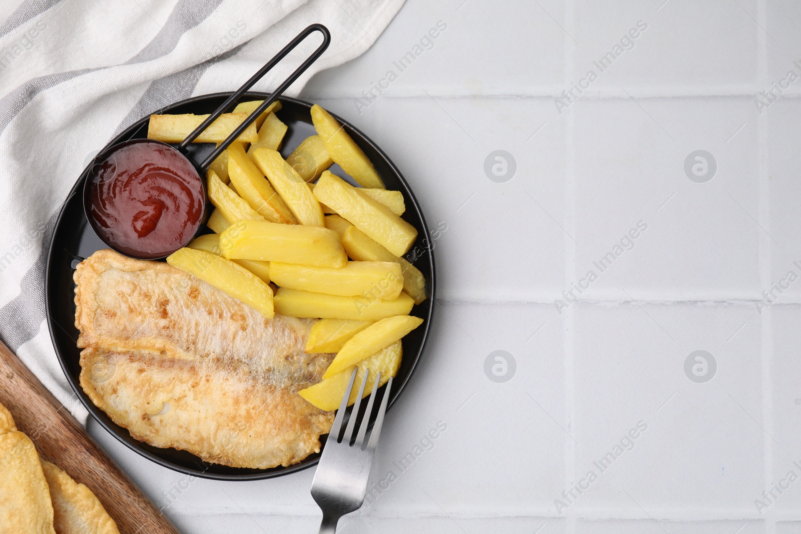 Photo of Delicious fish and chips served on white tiled table, flat lay. Space for text