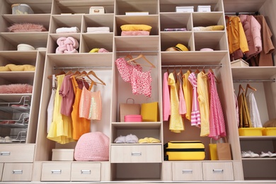 Photo of Stylish clothes, shoes and accessories in large wardrobe closet, below view