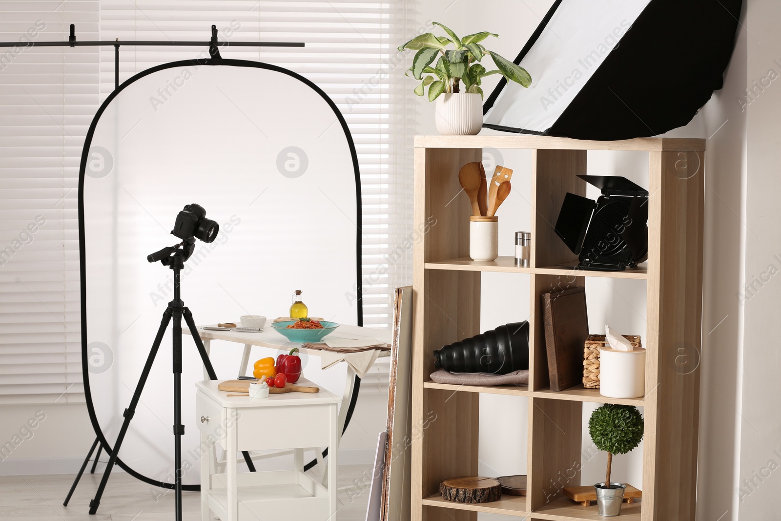 Photo of Professional equipment and composition with delicious spaghetti on white wooden table in studio. Food photography