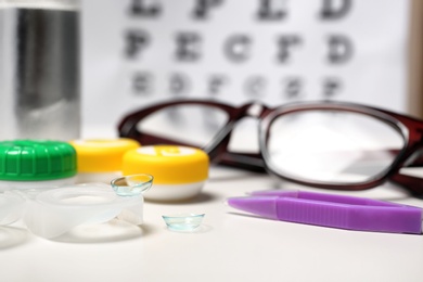 Photo of Contact lenses and tweezers on table, closeup