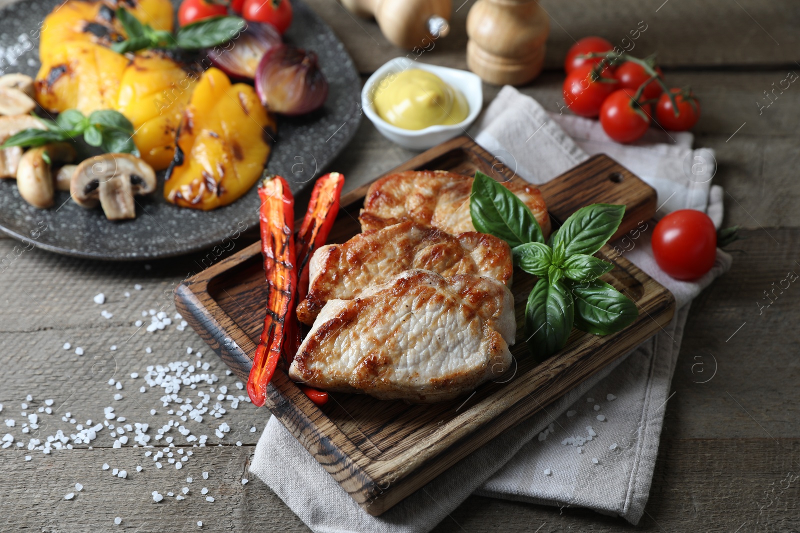 Photo of Delicious grilled meat and vegetables served on wooden table