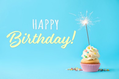 Image of Happy Birthday! Delicious cupcake with sparkler on light blue background