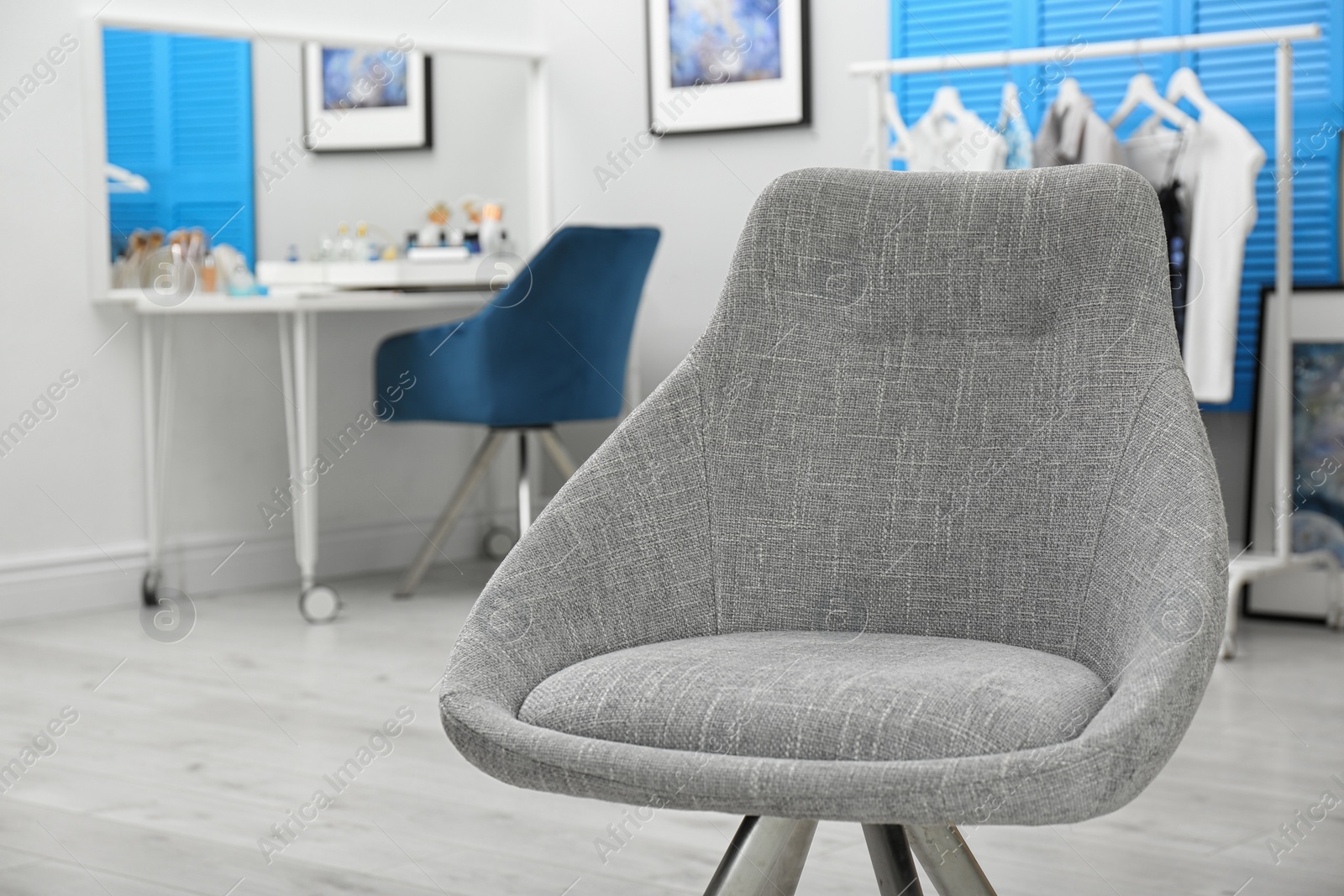 Photo of Makeup room interior with dressing table, focus on grey chair