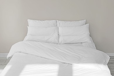 White soft pillows on cozy bed in room