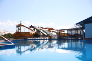 Photo of Blurred view of water park with swimming pool. Summer vacation