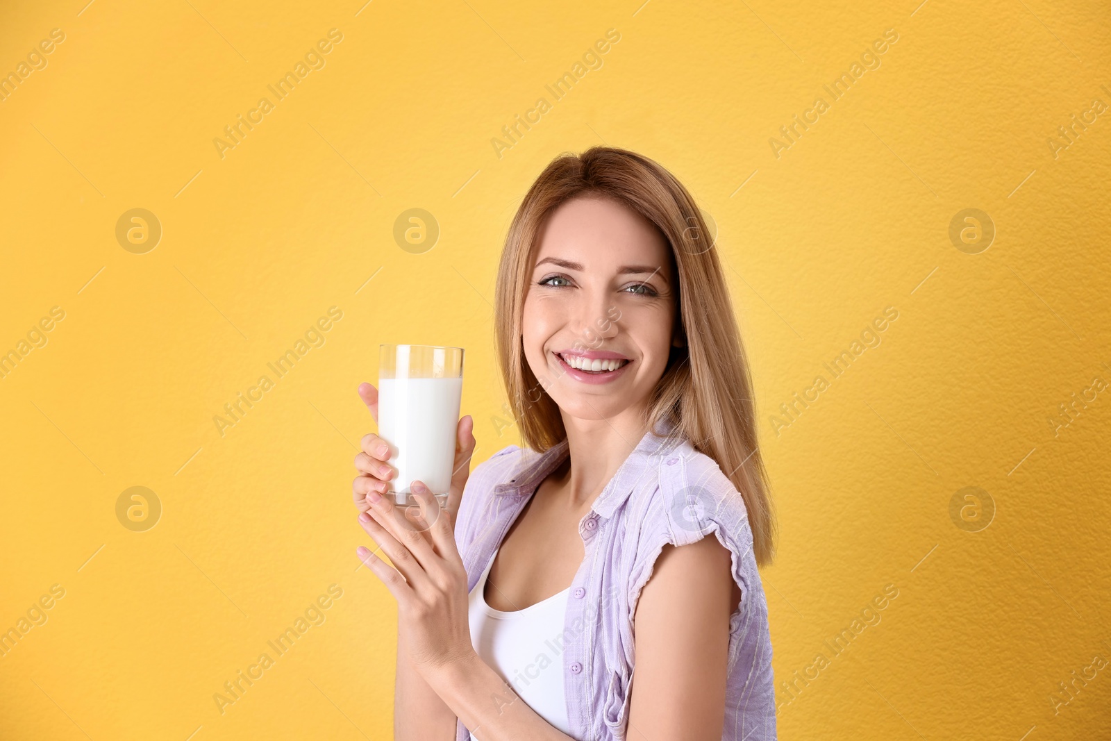 Photo of Beautiful young woman drinking milk on color background