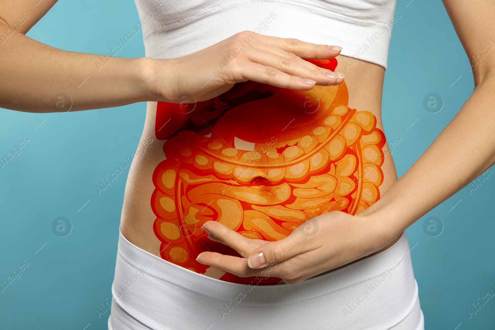 Image of Closeup view of woman with illustration of abdominal organs on her belly against light blue background