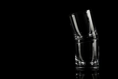 Photo of Empty whiskey glasses on black background. Space for text