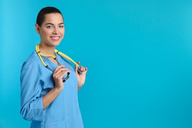 Photo of Portrait of young medical assistant with stethoscope on color background. Space for text