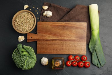 Photo of Wooden board surrounded by different ingredients on black table, flat lay with space for text. Cooking classes