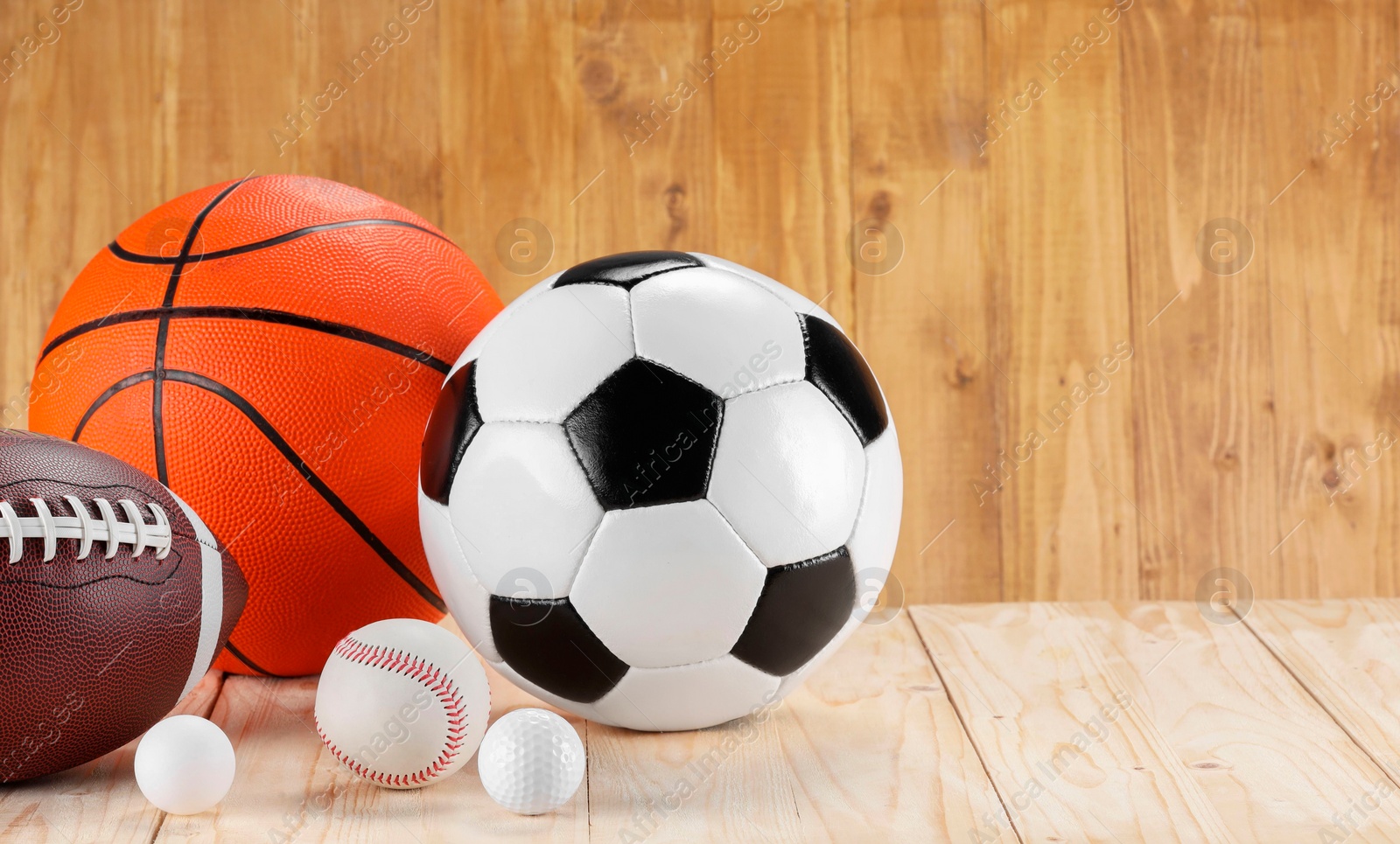 Photo of Many different sports balls on wooden background, space for text