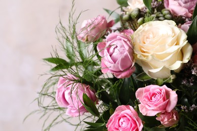 Photo of Beautiful bouquet with roses on beige background, closeup