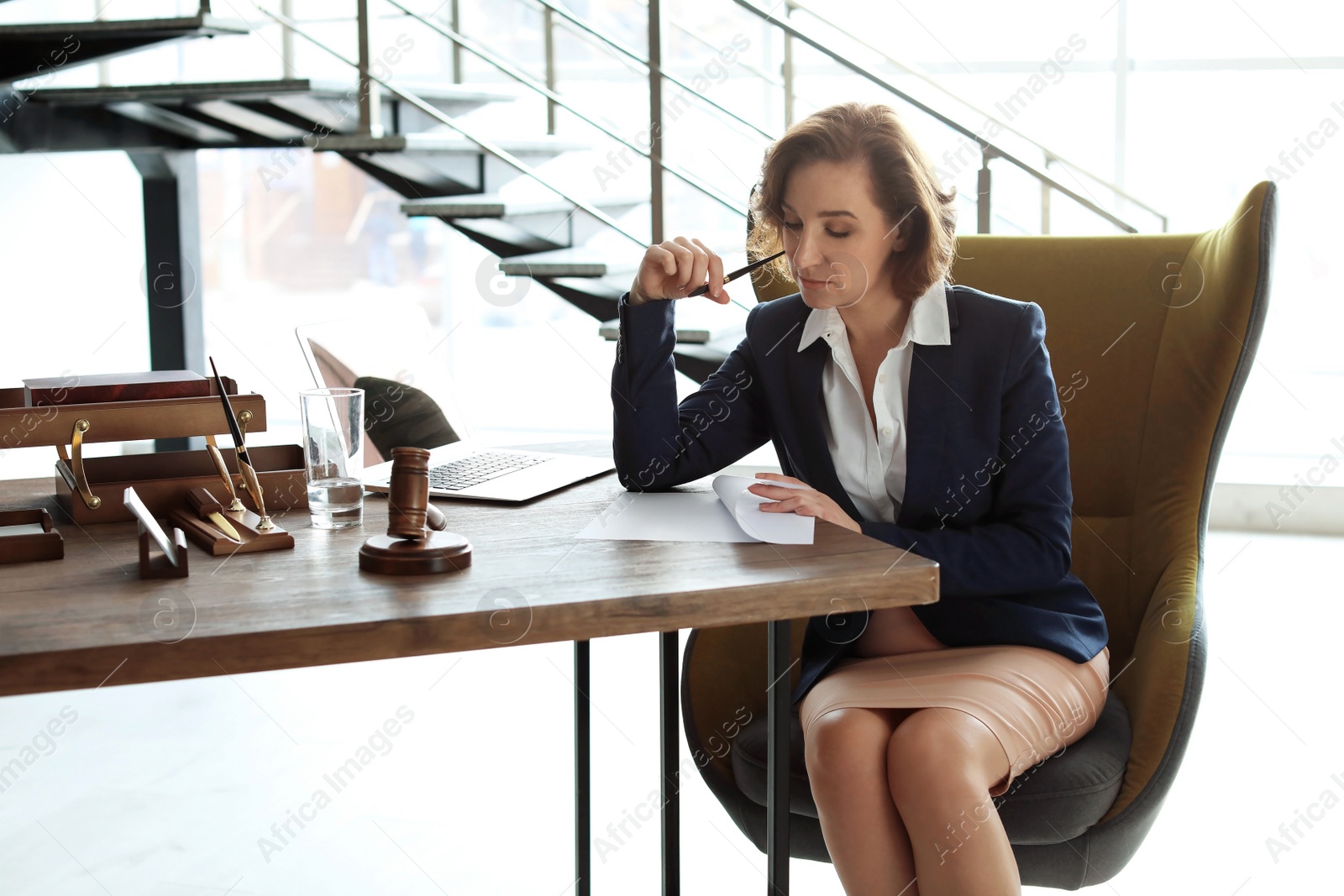 Photo of Female lawyer working at table in office