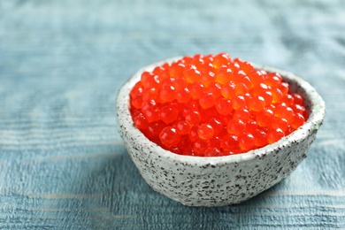 Ceramic bowl with delicious red caviar on table